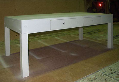 Three-quarter view of a white coffee table with two drawers