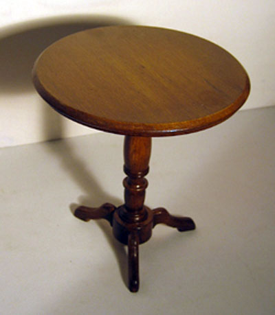 Top view of a round occasional table with a turned support and three small legs